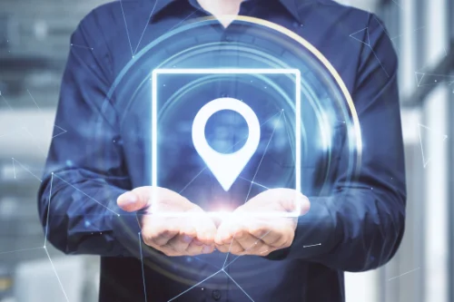 Photo d'un professionnel tenant une main lumineuse avec épingle GPS - suivi discret d'objets sensibles en Tunisie